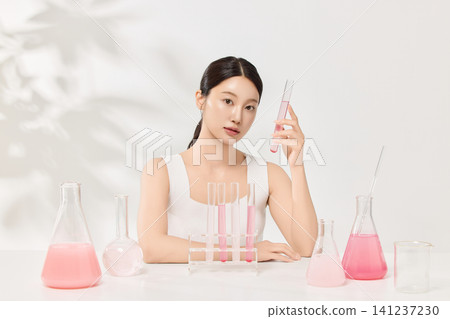 Woman examining cosmetic ingredients in flasks for a skincare concept Woman examining cosmetic ingredients in flasks for a skincare concept 141237230