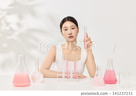 Asian woman posing with laboratory glassware and pink beauty serum Asian woman posing with laboratory glassware and pink beauty serum 141237231