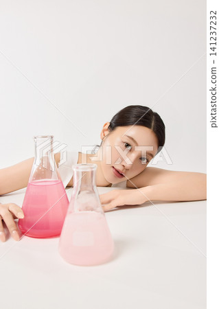 Young Asian woman holding an amber skincare serum bottle Young Asian woman holding an amber skincare serum bottle 141237232