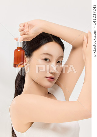 Woman presenting facial serum for a skincare routine concept Woman presenting facial serum for a skincare routine concept 141237242