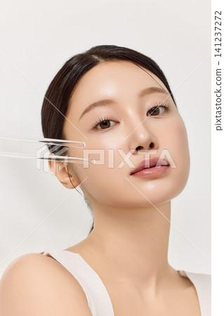 Beauty portrait of an Asian woman framed by clear glass tubes Beauty portrait of an Asian woman framed by clear glass tubes 141237272