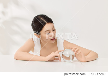 Woman applying serum with a dropper for a skincare routine 141237280