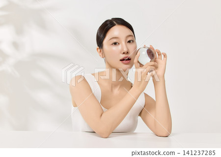 Woman applying serum with a dropper for a skincare routine Woman applying serum with a dropper for a skincare routine 141237285
