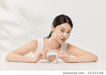 Asian woman demonstrating facial care and moisturizing cream 141237286