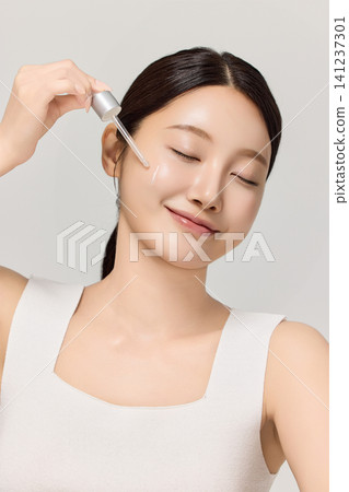 Asian woman demonstrating facial care and moisturizing cream Asian woman demonstrating facial care and moisturizing cream 141237301