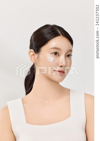 Woman applying serum with a dropper for a skincare routine Woman applying serum with a dropper for a skincare routine 141237302