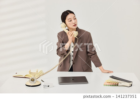 Female office worker reviewing color swatches and documents Female office worker reviewing color swatches and documents 141237351
