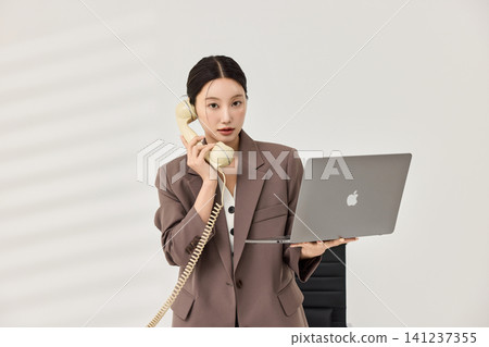 Female office worker reviewing color swatches and documents Female office worker reviewing color swatches and documents 141237355