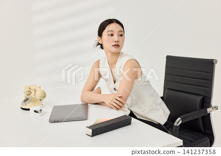 Professional woman holding a pen during office planning work Professional woman holding a pen during office planning work 141237358