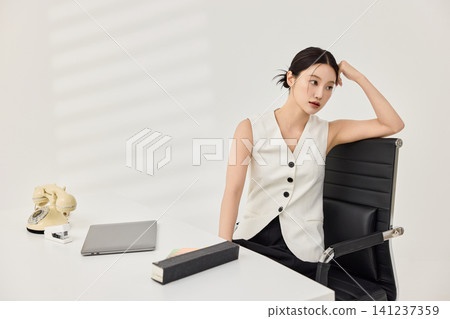 Businesswoman reading papers in a minimalist office setting Businesswoman reading papers in a minimalist office setting 141237359