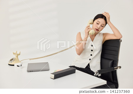 Female designer working with a laptop and printed materials Female designer working with a laptop and printed materials 141237360