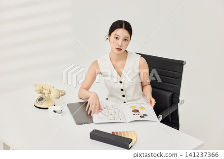 Professional woman holding a pen during office planning work Professional woman holding a pen during office planning work 141237366