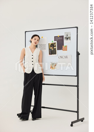 Female designer standing beside a project board with reference images Female designer standing beside a project board with reference images 141237384