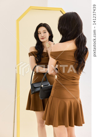 Asian woman preparing an outfit before going out Asian woman preparing an outfit before going out 141237439