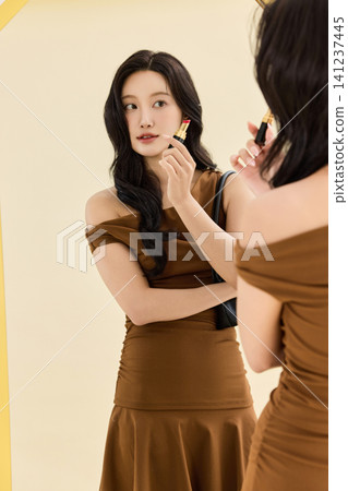 Fashionable woman choosing handbags in front of a mirror Fashionable woman choosing handbags in front of a mirror 141237445