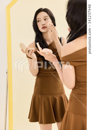 Woman styling a brown dress with a coat and handbag Woman styling a brown dress with a coat and handbag 141237446
