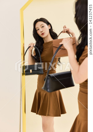 Asian woman preparing an outfit before going out Asian woman preparing an outfit before going out 141237455