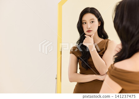 Asian woman preparing an outfit before going out Asian woman preparing an outfit before going out 141237475