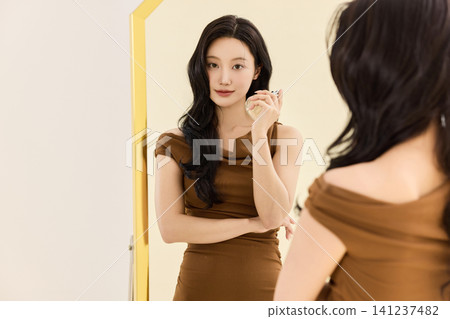 Woman styling a brown dress with a coat and handbag Woman styling a brown dress with a coat and handbag 141237482