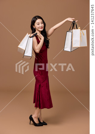 Woman carrying shopping bags after a festive sale Woman carrying shopping bags after a festive sale 141237645