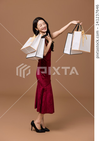 Asian woman pushing a shopping cart filled with wrapped gifts Asian woman pushing a shopping cart filled with wrapped gifts 141237646