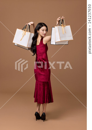 Elegant woman holding shopping bags and a black sale card Elegant woman holding shopping bags and a black sale card 141237650