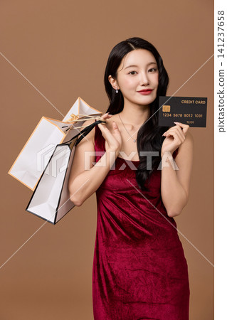 Elegant woman holding shopping bags and a black sale card Elegant woman holding shopping bags and a black sale card 141237658