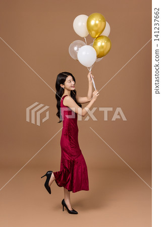Elegant woman celebrating with balloons and a glass of wine Elegant woman celebrating with balloons and a glass of wine 141237662
