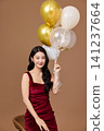 Celebration portrait with gold balloons and wine glass 141237664