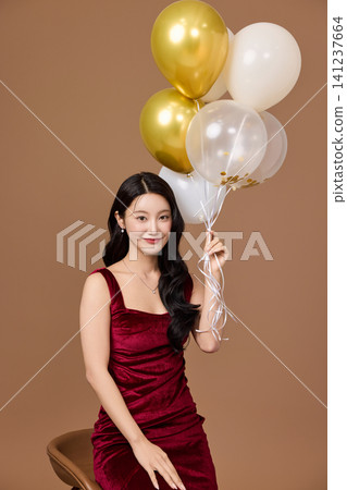 Celebration portrait with gold balloons and wine glass Celebration portrait with gold balloons and wine glass 141237664