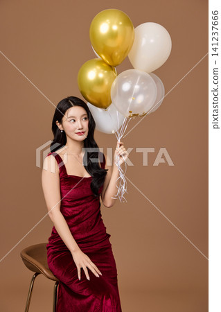 Elegant woman celebrating with balloons and a glass of wine Elegant woman celebrating with balloons and a glass of wine 141237666