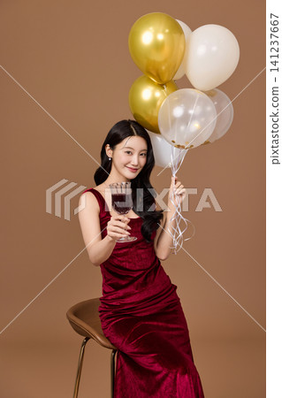 Celebration portrait with gold balloons and wine glass Celebration portrait with gold balloons and wine glass 141237667