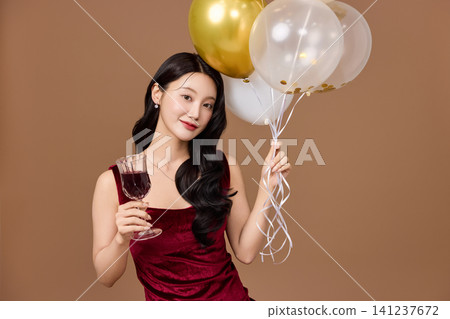 Celebration portrait with gold balloons and wine glass Celebration portrait with gold balloons and wine glass 141237672