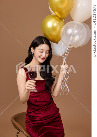 Festive party concept with an elegant woman in a red dress Festive party concept with an elegant woman in a red dress 141237673