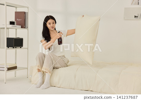 Asian woman sitting in bed with a glass of water 141237687