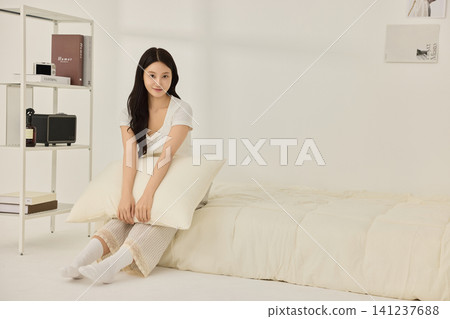 Young Asian woman drinking water on a bed in the morning Young Asian woman drinking water on a bed in the morning 141237688