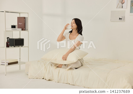 Healthy morning routine with water and vitamins on a bed Healthy morning routine with water and vitamins on a bed 141237689