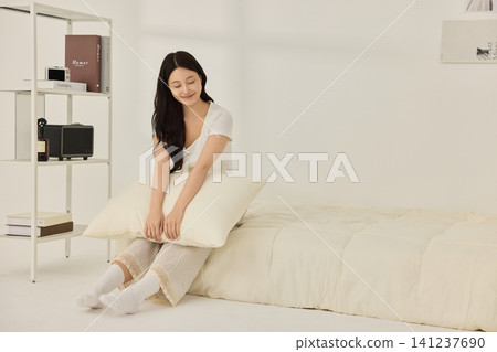 Woman taking a supplement with water in a bright bedroom Woman taking a supplement with water in a bright bedroom 141237690