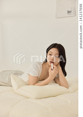 Relaxed home lifestyle with a woman journaling in bed Relaxed home lifestyle with a woman journaling in bed 141237698
