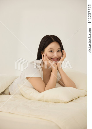 Morning wake-up concept with a woman and alarm clock Morning wake-up concept with a woman and alarm clock 141237725