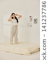 Playful morning lifestyle portrait with a woman on a cream bed 141237786