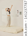 Asian woman posing with a pillow in a white bedroom 141237787