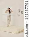 Playful morning lifestyle portrait with a woman on a cream bed 141237791