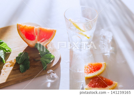 Soft focus grapefruit drink scene with mint, ice and bright summer reflections 141239165