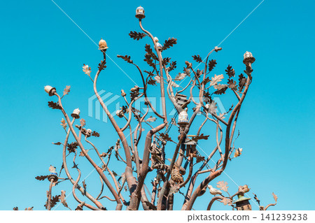 Close-up of metal tree branches with birdhouses and acorns Close-up of metal tree branches with birdhouses and acorns 141239238