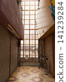 A nostalgic scene at the end of a closed-off shopping street, blocked off with corrugated iron sheets. 141239284