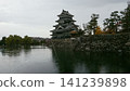 Matsumoto Castle, its moat, and stone walls in autumn 141239898