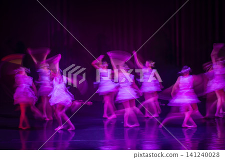 Dancers performing on stage with motion blur and purple lighting 141240028