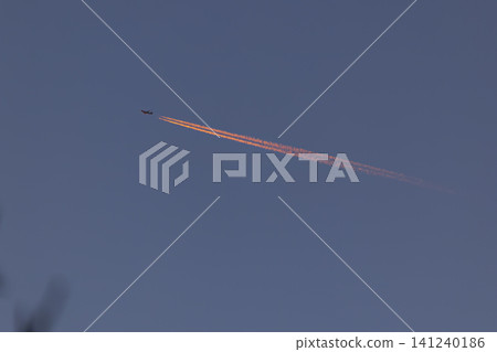Airplane contrail streaking across sunset light sky Airplane contrail streaking across sunset light sky 141240186