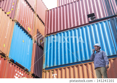 Happy Winner manager, Foreman shipping staff working at Container cargo rising hand and pointing finger for Win in Logistic Business. Leader stand on above container. 141241101